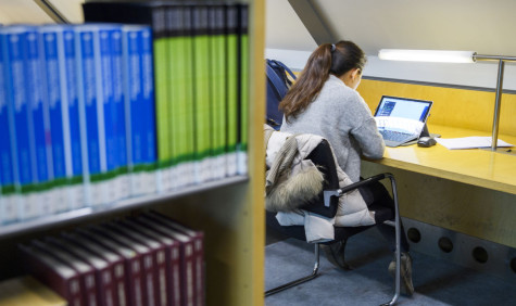 Studente werkt op laptop in bibliotheek