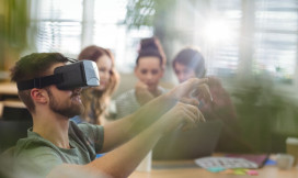 Man met VR-bril op en vrouwen in de achtergrond