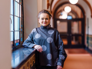 Alexandra van Huffelen staat in de gang van het Berchmanium klooster van de Radboud Universiteit