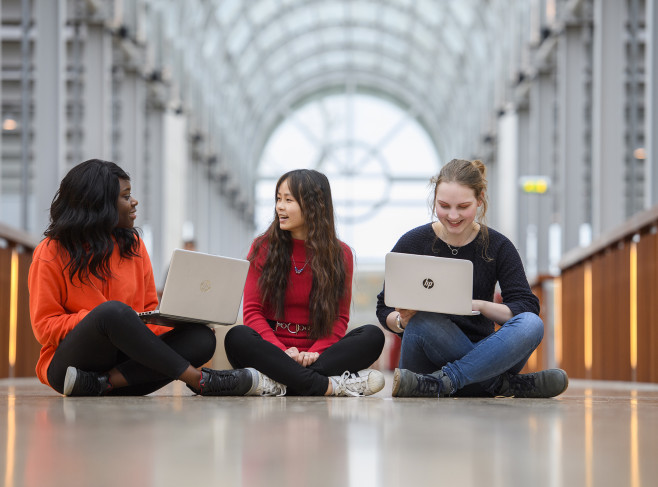 studenten in Zwolle zitten op de grond met laptop